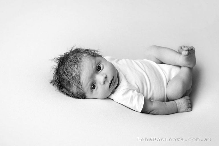 Newborn photo shoot natural studio style - baby wearing white on white awake portrait