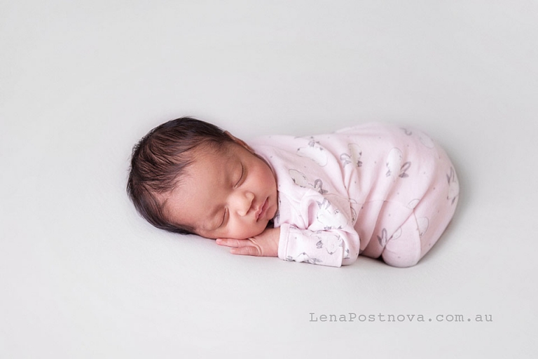 Newborn baby wering pink babysuit - Natural Newborn Photography 