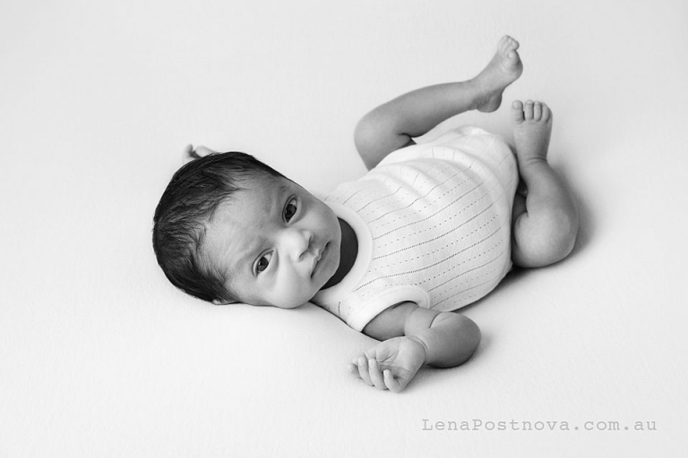 baby wering white onesie looking at the camera