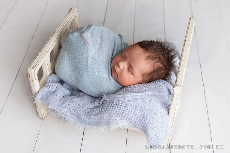 Newborn photography - baby boy in the tiny bed
