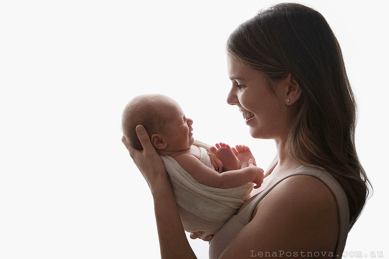 mum and baby both smiling at their photoshoot for newborn