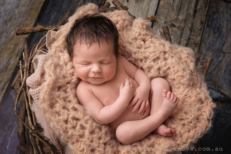 Newborn baby smiles posed in the nest