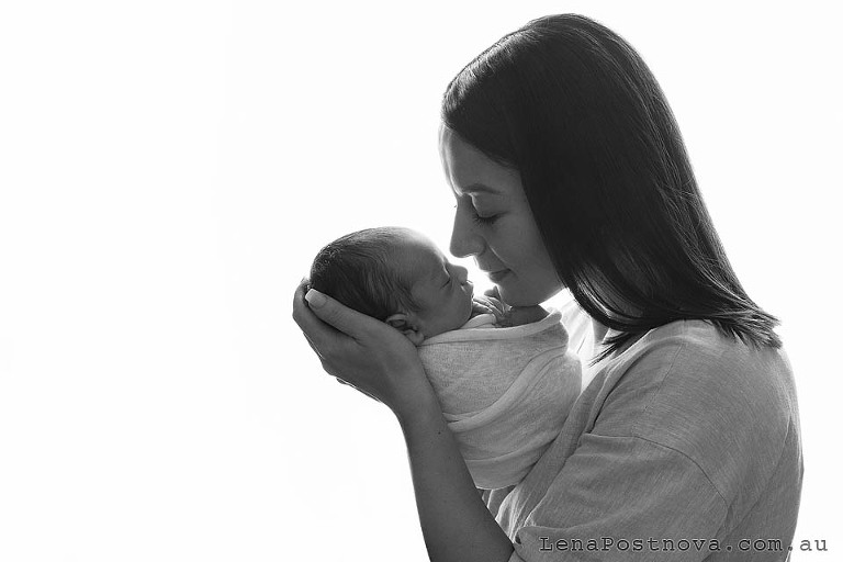 backlit portrait of mother with the newborn