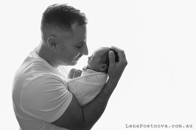 backlit portrait of dad with the newborn