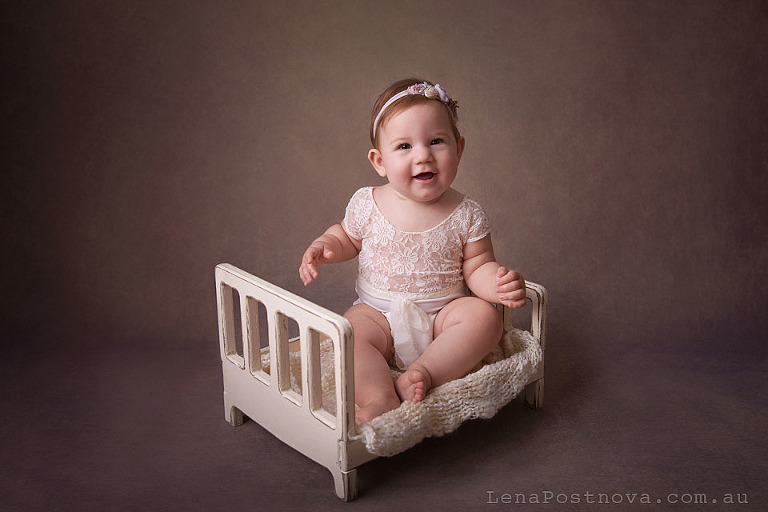 studio portrait of 8 months old baby girl sitting on a tiny bed - Sydney baby photo session 