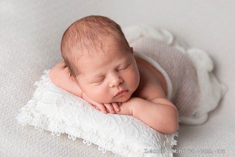 newborn baby girl on a lace pillow