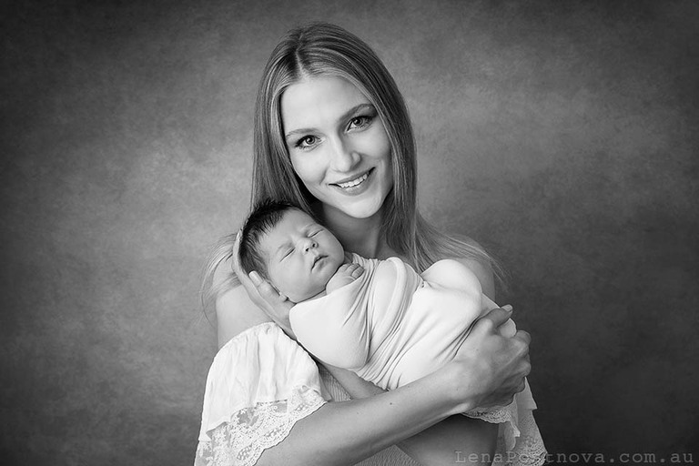 smiling mother with her newborn baby girl