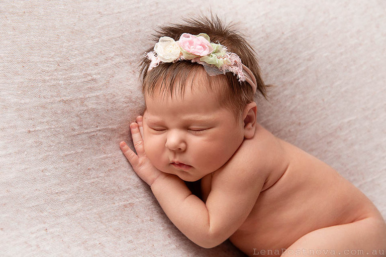 gorgeous newborn baby girl wearing a flower headband