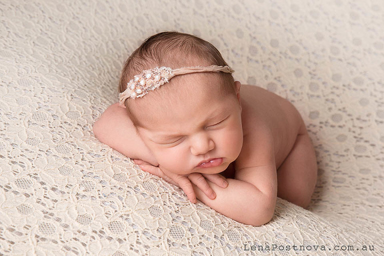 baby girl posed on the tummy with pearl headband 