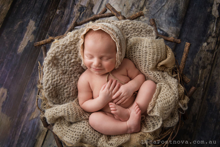 beautiful baby smiling in her sleep posed in the nest