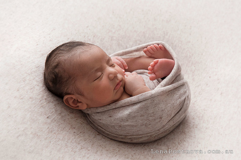 backlit newborn baby wrapped