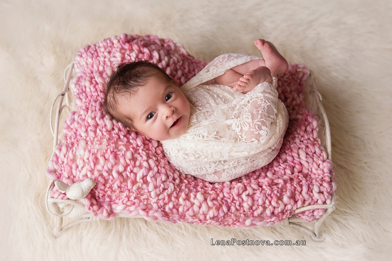 newborn girl in a prop bed at newborn photography session