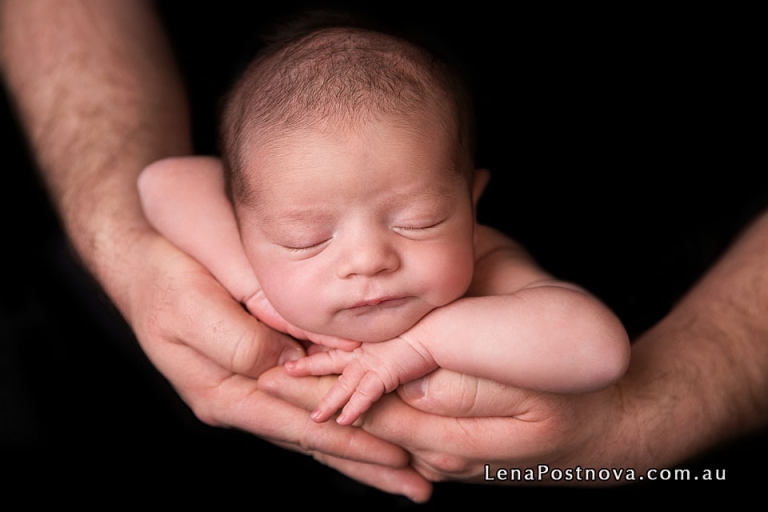 father holding newborn son in his hands by Sydney North baby newborn photographer