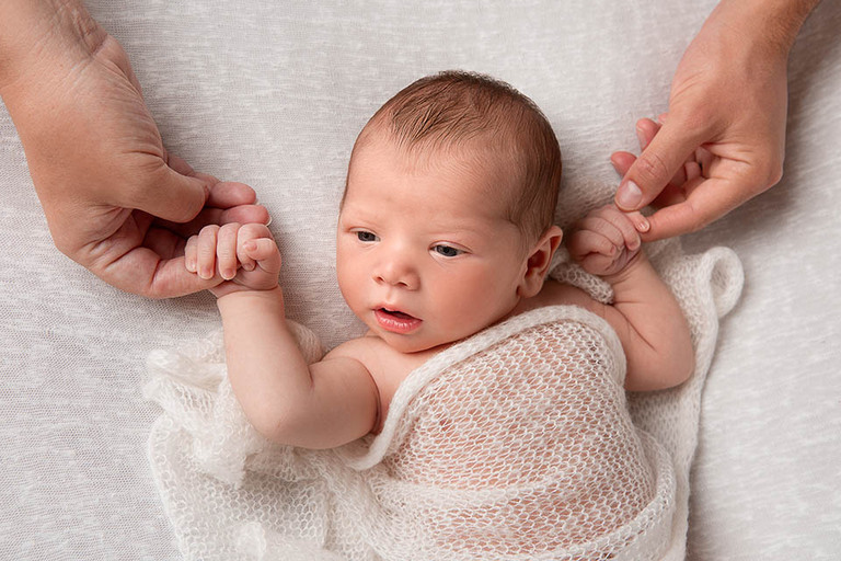 Before and After Newborn Photoshoot Sydney – baby holding parents’ hands during in-home session