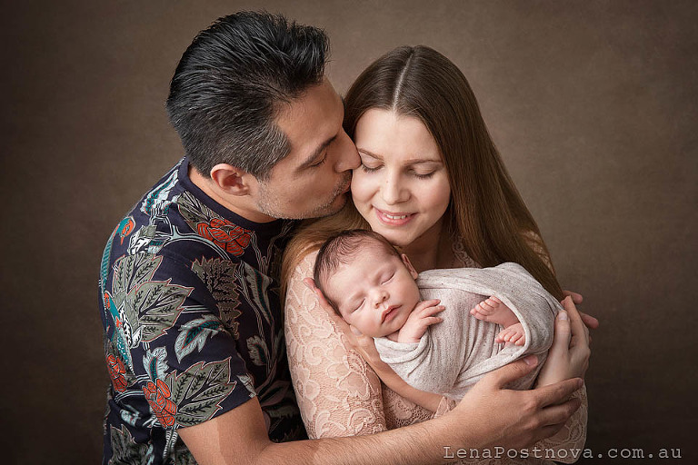dad kissing mum at newborn photography session