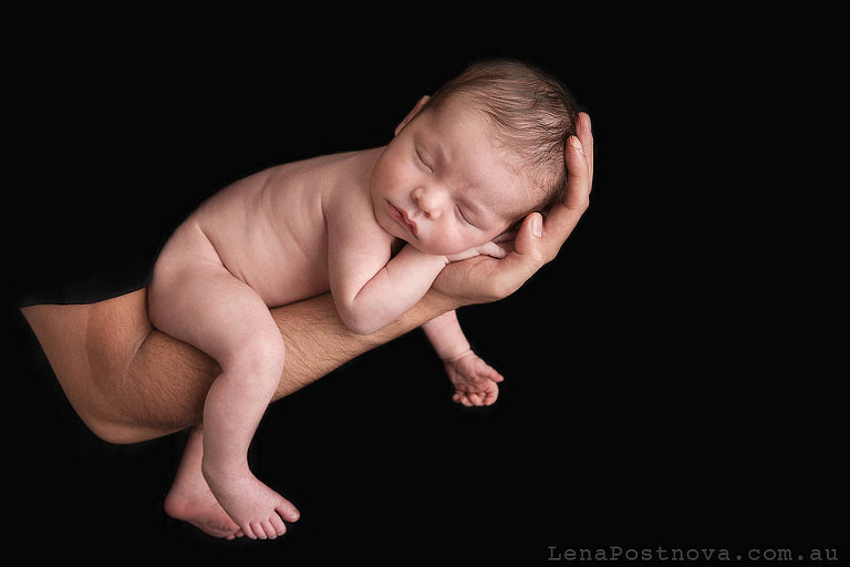 newborn baby in dad's arms